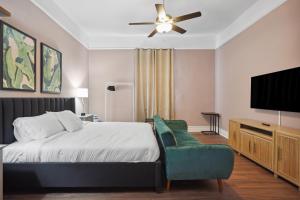 a bedroom with a bed and a flat screen tv at The Balcony House II in New Orleans