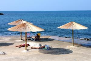 two people laying on the beach under umbrellas at Apartments with a parking space Mareda, Novigrad - 7100 in Novigrad Istria