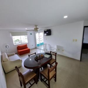 - un salon avec une table, des chaises et un canapé dans l'établissement Apartamento en Santa Marta Brisa Marina 8 by reservastodo, à Santa Marta