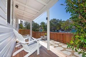 a white rocking chair on the porch of a house at Fishery Road Cottage Pet Friendly 2 Mins Walk to Beach in Currarong