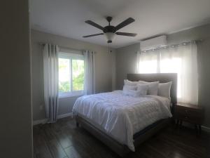 羅阿坦的住宿－Single-Family Home With Gated Tropical Yard，一间卧室配有一张带吊扇的床