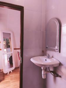 La salle de bains est pourvue d'un lavabo et d'un miroir. dans l'établissement Mercy Cottage, à Langgur