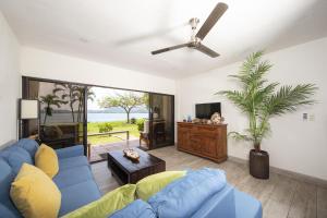 sala de estar con sofá azul y TV en Newly Remodeled Ground-Floor Unit in Flamingo in Front of Beach, en Playa Flamingo