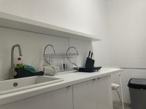 een witte keuken met een wastafel en een aanrecht bij L83 - rooms and apartments in Lissabon