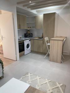 een keuken met een wasmachine en een wasmachine bij Nanterre : Super appartement tout confort in Nanterre