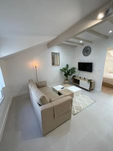 een woonkamer met een bank en een tv bij Nanterre : Super appartement tout confort in Nanterre