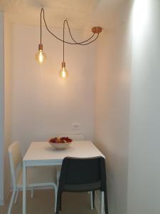 a table with two chairs and a bowl of fruit on it at Apartment Valbandon 7296b in Štinjan