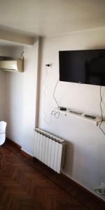 Cette chambre est dotée d'un mur avec une télévision et un radiateur. dans l'établissement Hermoso departamento a 30 metros de paseo Balcarce, à Salta