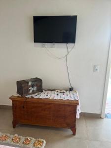 a room with a tv and a table with pizza at Pousada Dona Terezinha in Formiga