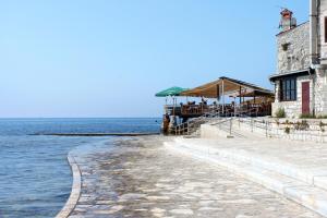 przejście obok wody obok budynku w obiekcie Apartments with a parking space Umag - 7147 w mieście Umag +14 zdjęć