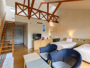 Habitación con 2 camas, 2 sillas y escalera. en Tabist Villa Daio Resort Ise-Shima, en Shima