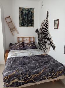um quarto com uma cama com uma escultura de zebra na parede em NEW! Great Location! Vibrant Downtown, Talpiot Market, Flea Market, Carmel Beach, close to everywhere em Haifa