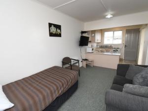a hotel room with a bed and a couch at Avon Motel in Hawera