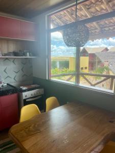 路易斯科雷亞的住宿－CHALEVILLE Coqueiro 46，厨房配有木桌和大窗户。