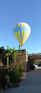 a large blue and yellow kite is in the air at Guzide Cave Hotel in Goreme