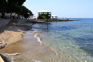 a beach with a gazebo next to the water at Apartments with parking space Umag - 6994 in Umag +13 photos