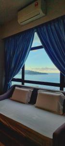 - une chambre avec un lit et une vue sur l'océan dans l'établissement Nana Homestay - Jesselton quay, à Kota Kinabalu