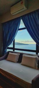 a bedroom with a bed with a view of the ocean at Nana Homestay - Jesselton quay in Kota Kinabalu