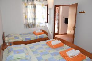 una camera con 2 letti singoli e una TV di Apartments and rooms by the sea Jakisnica, Pag - 4160 a Lun