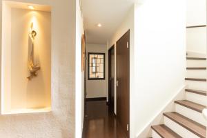 a hallway of a house with white walls and stairs at 箱寝荘 - Hakoneso in Hakone