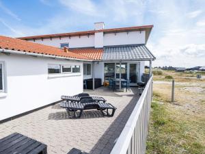 une terrasse avec deux bancs et une maison dans l'établissement Holiday home Hvide Sande L, à Bjerregård