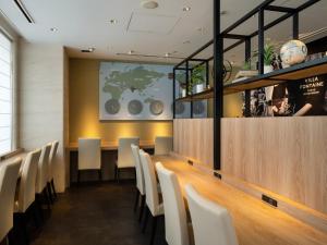 a dining room with a long table and white chairs at Hotel Villa Fontaine Tokyo-hatchobori in Tokyo