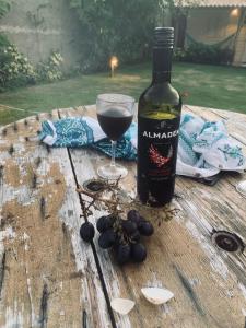 a bottle of wine and a glass on a wooden table at Chalés XIÉ in São Miguel dos Milagres