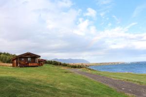 a cabin on a hill next to a body of water at Ytri Vík in Hauganes