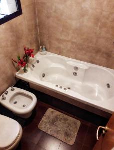 a bathroom with a white tub and a toilet at Casa Roca in San Carlos de Bariloche