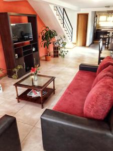 Una sala de estar con un sofá rojo y una mesa de café. en Casa Roca, en San Carlos de Bariloche