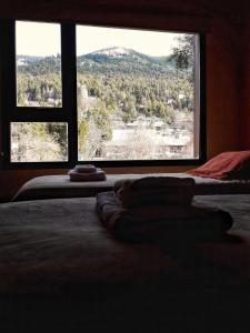 a bedroom with two beds and a large window at Casa Roca in San Carlos de Bariloche