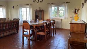 uma sala de jantar com uma mesa de madeira e cadeiras em Villa Baleia, São Julião Beach - Ericeira na Ericeira