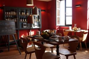 a dining room with red walls and a table and chairs at Hôtel Courtille de Solutré in Solutré-Pouilly
