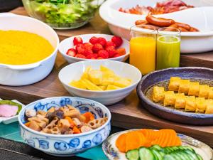 a wooden table topped with bowls of different types of food at Utsunomiya Tobu Hotel Grande in Utsunomiya