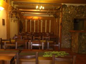 a dining room with tables and chairs and a stone wall at Dom Mysliwski in Kobyłka