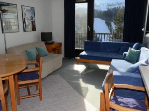 a living room with blue couches and a table and a balcony at Appartement Flaine, 2 pièces, 6 personnes - FR-1-425-137 in Arâches-la-Frasse