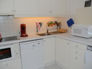 a kitchen with white cabinets and a sink at Appartement Flaine, 2 pièces, 6 personnes - FR-1-425-137 in Arâches-la-Frasse