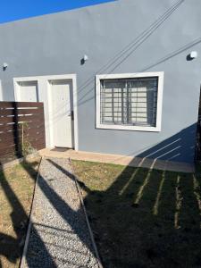 una casa blanca con una ventana y una valla en Apart del Este 2, en Paysandú