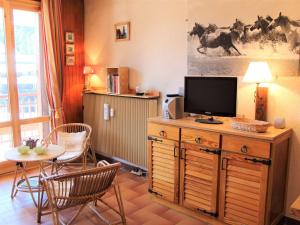 sala de estar con TV y mesa con sillas en Appartement Vars, 1 pièce, 4 personnes - FR-1-330B-195, en Vars