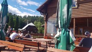 a group of people sitting at benches with umbrellas at Domek na wsi in Długosiodło