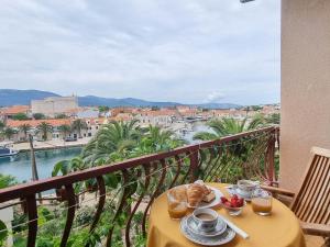 a table with food on a balcony with a view at Triple Room Vrboska 540e in Vrboska