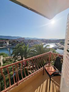 a balcony with a view of a river and palm trees at Apartments and rooms by the sea Vrboska (Hvar) - 540 in Vrboska