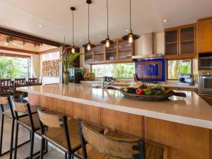 a kitchen with a large island with a bowl of fruit on it at Villa Waimarie - SHA Extra Plus in Lipa Noi