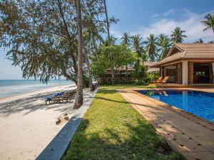 a house with a swimming pool next to the beach at Villa Waimarie - SHA Extra Plus in Lipa Noi