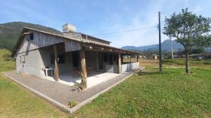 a small house in the middle of a field at Hostel e Camping Vale Mirante da Rocha in Timbe do Sul