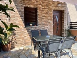 a patio with a table and chairs in front of a brick wall at Felicia`s House in Agria
