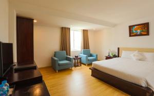 um quarto de hotel com uma cama e duas cadeiras azuis em ALUNA Ben Thanh Hotel em Cidade de Ho Chi Minh