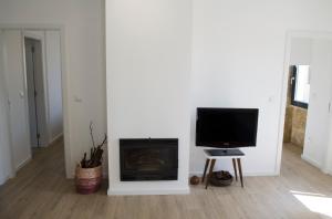 un salon avec une télévision et une cheminée dans l'établissement Sabor@Arte, à Couto de Esteves