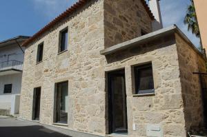 ein Steingebäude mit Fenstern an der Seite in der Unterkunft Sabor@Arte in Couto de Esteves