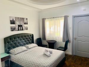 ein Schlafzimmer mit einem Bett, einem Stuhl und einem Fenster in der Unterkunft 3 Peaks Resort & Boutique Hotel in Lipa